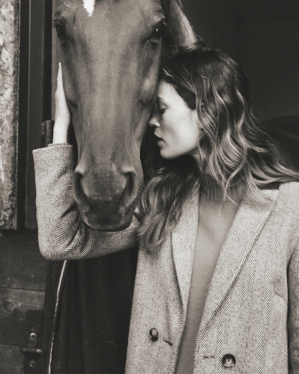 Modelka pózující s koněm v elegantním kabátu
