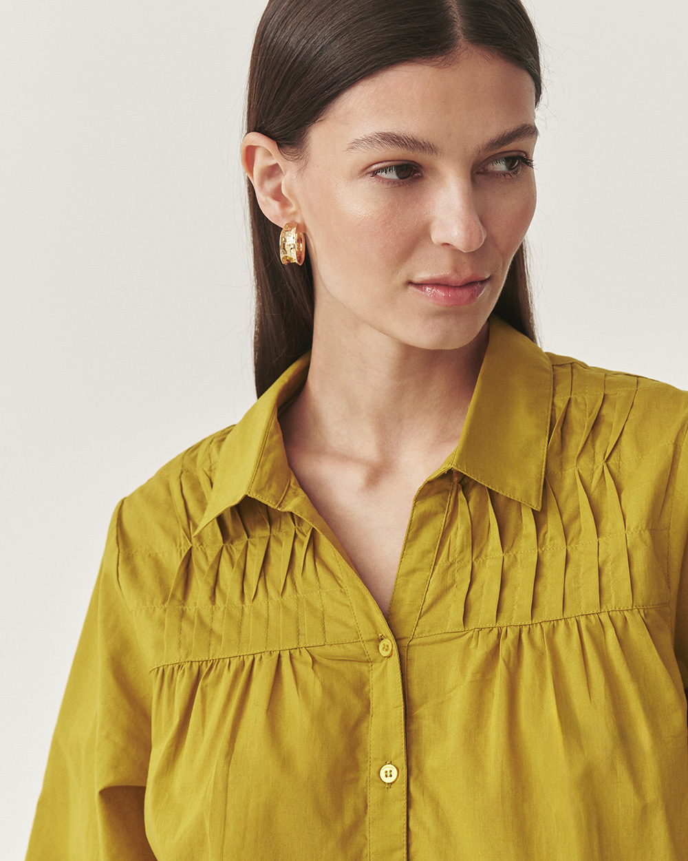 prim-plan al unei femei îmbrăcată într-o cămașă elegantă cu volane decorative