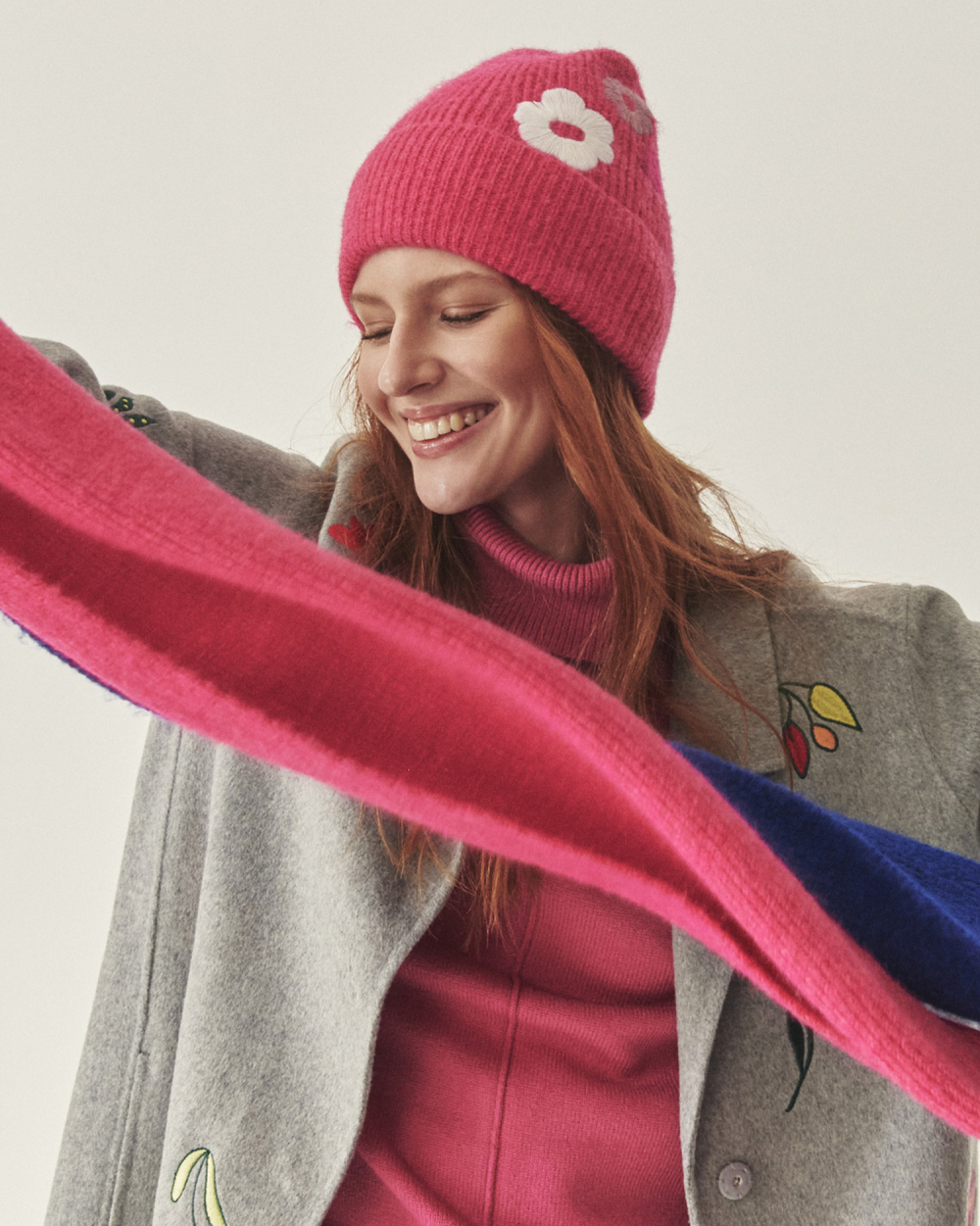 usmívající se žena v kabátě, šále a čepici