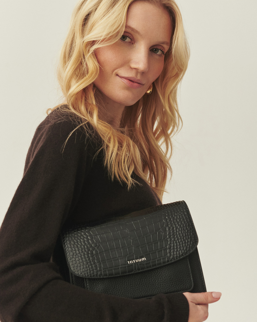 Kobieta z zamszową, brązową torbą przewieszoną przez ramię