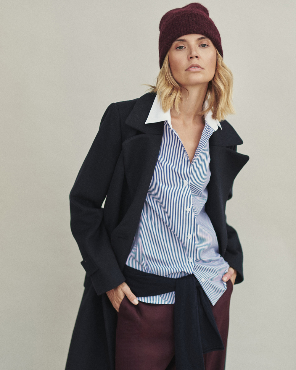 žena v elegantnom čiernom kabáte a klobúku