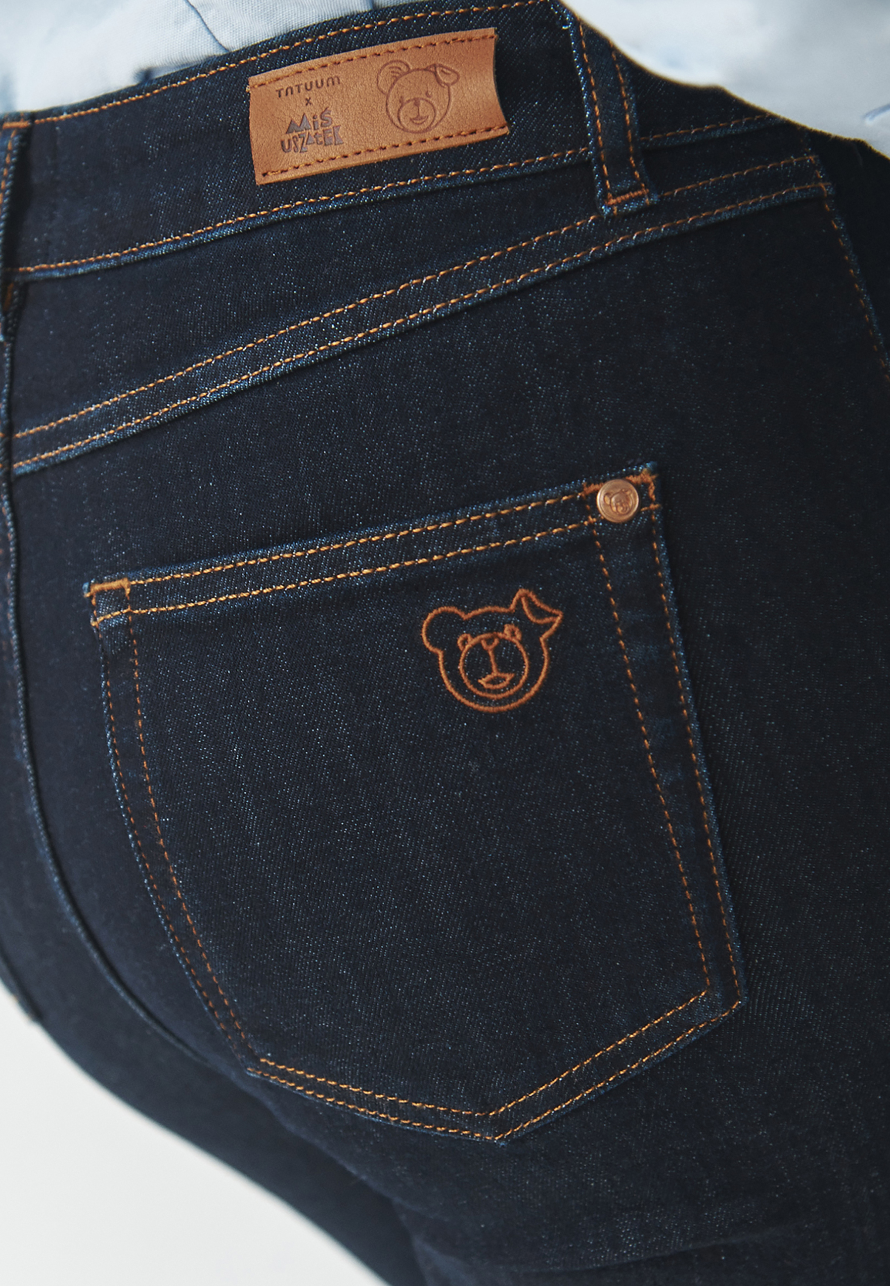 DENIMOWE SPODNIE DAMSKIE O KROJU BOOTCUT Z MOTYWEM MISIA USZATKA — RIFONO 1 GRANATOWY 2