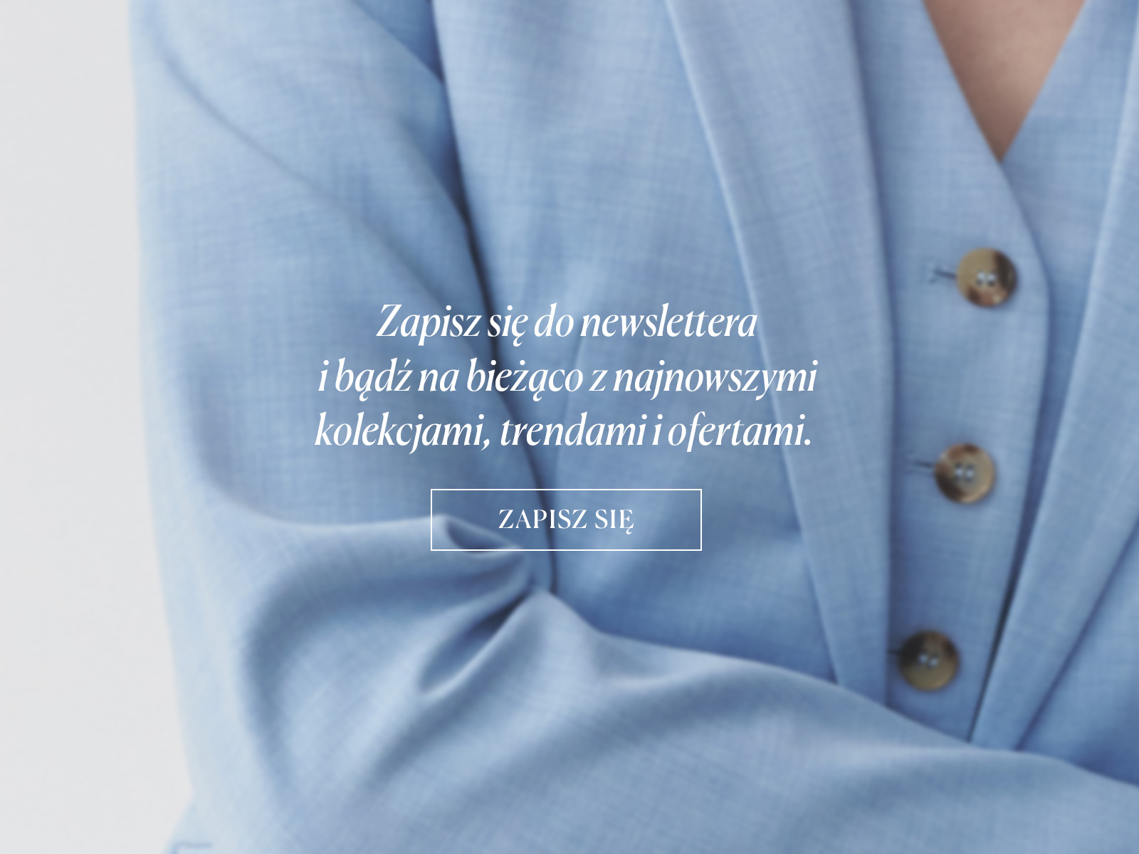 Zbliżenie na rękaw błękitnego żakietu z tekstem promującym zapis do newslettera na tle eleganckiego materiału.