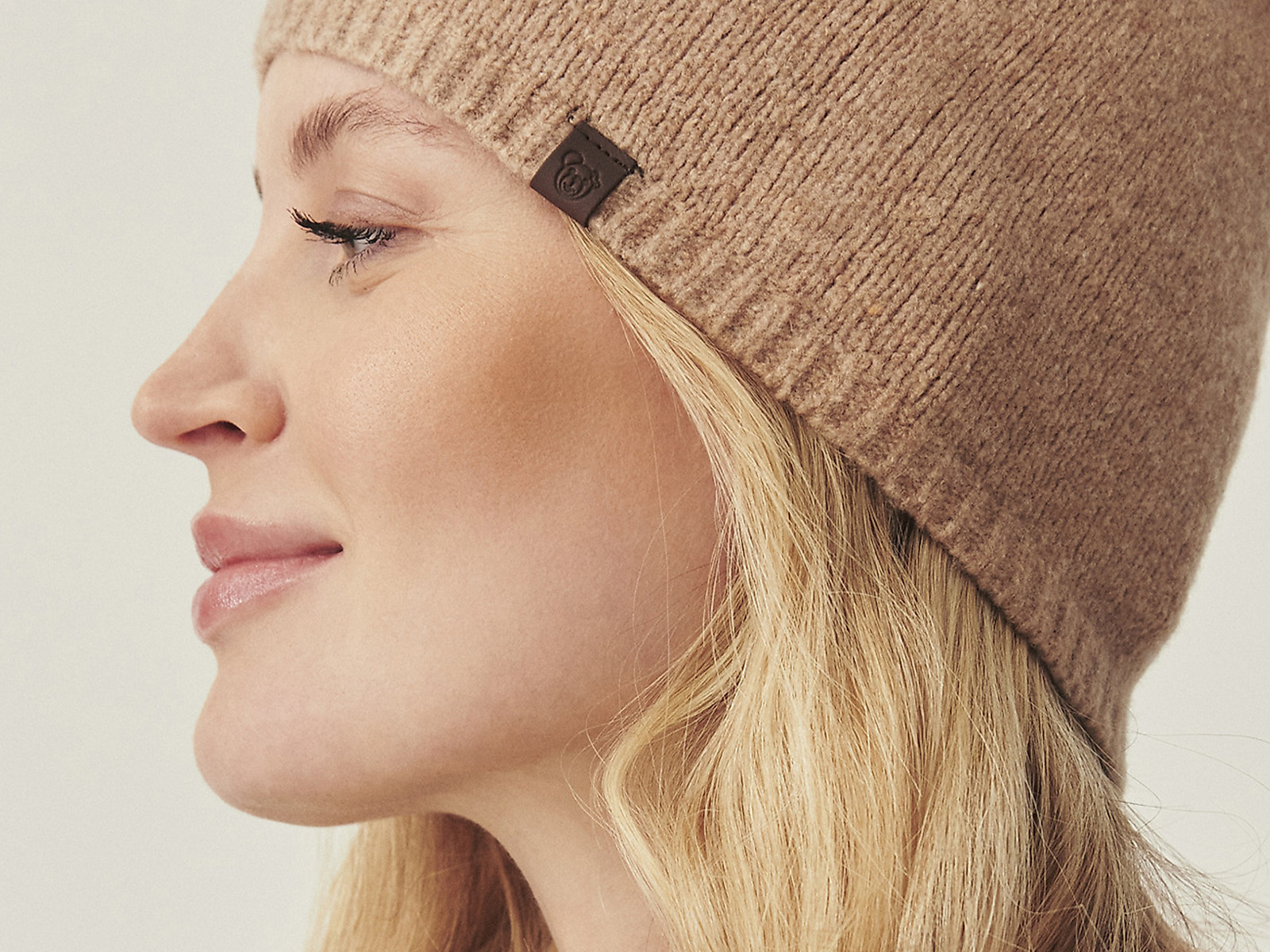 přiblížení na tvář ženy v béžové zimní čepici