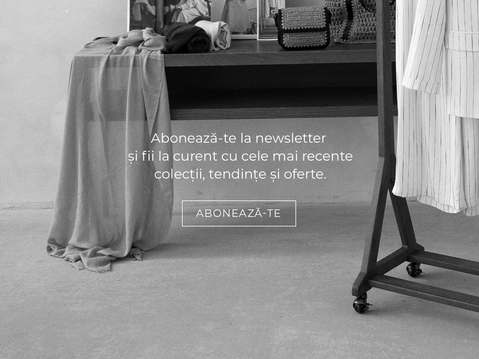 Text de încurajare pentru abonarea la newsletter, pe fundal cu țesături și haine expuse.