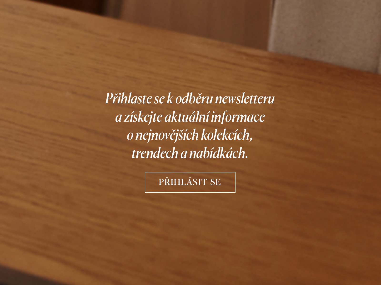 Detailní záběr na dřevěnou desku stolu s nápisem vybízejícím k odběru newsletteru.