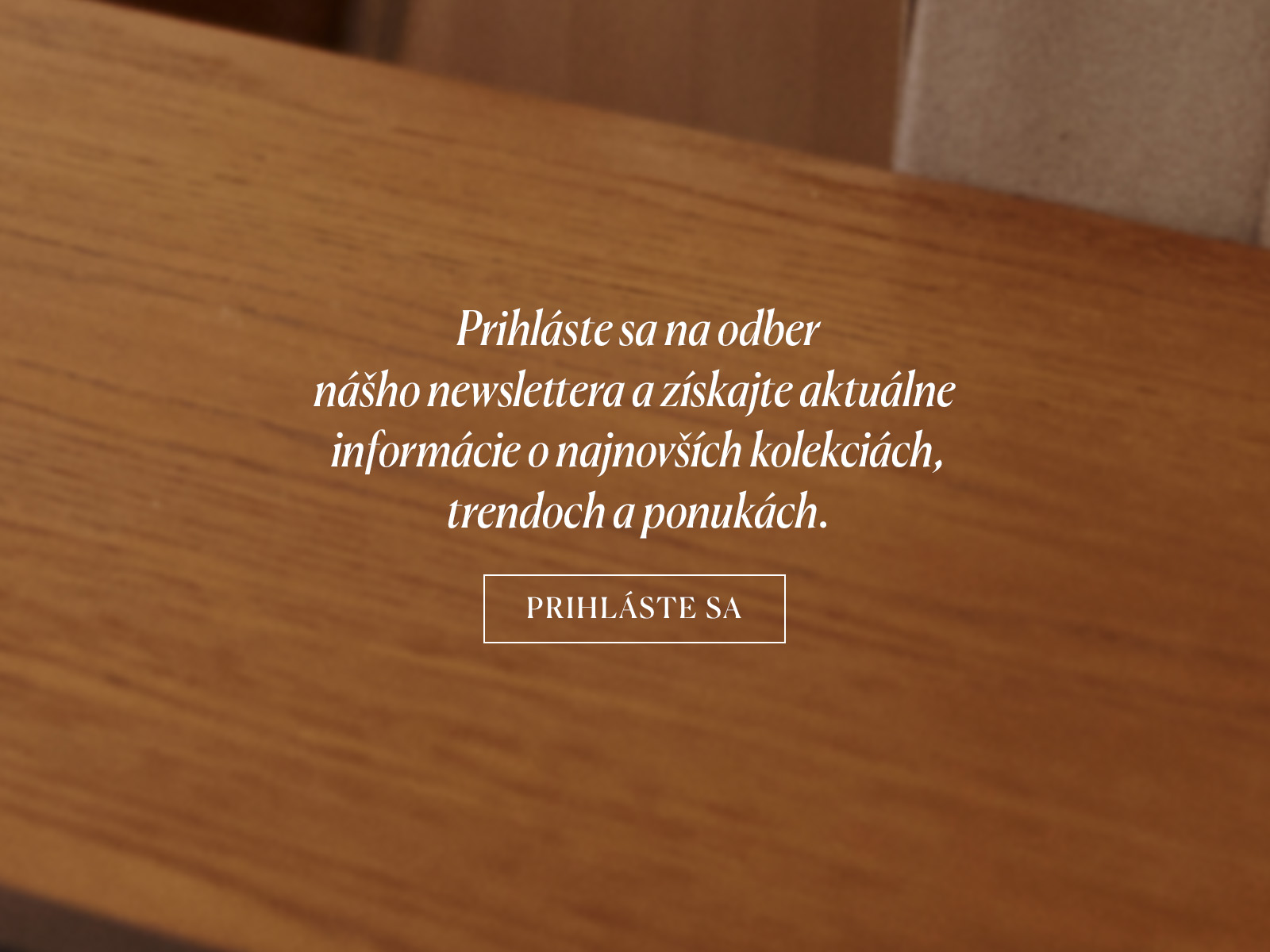 Detailný záber na drevenú dosku stola s nápisom vyzývajúcim na odber newslettera.