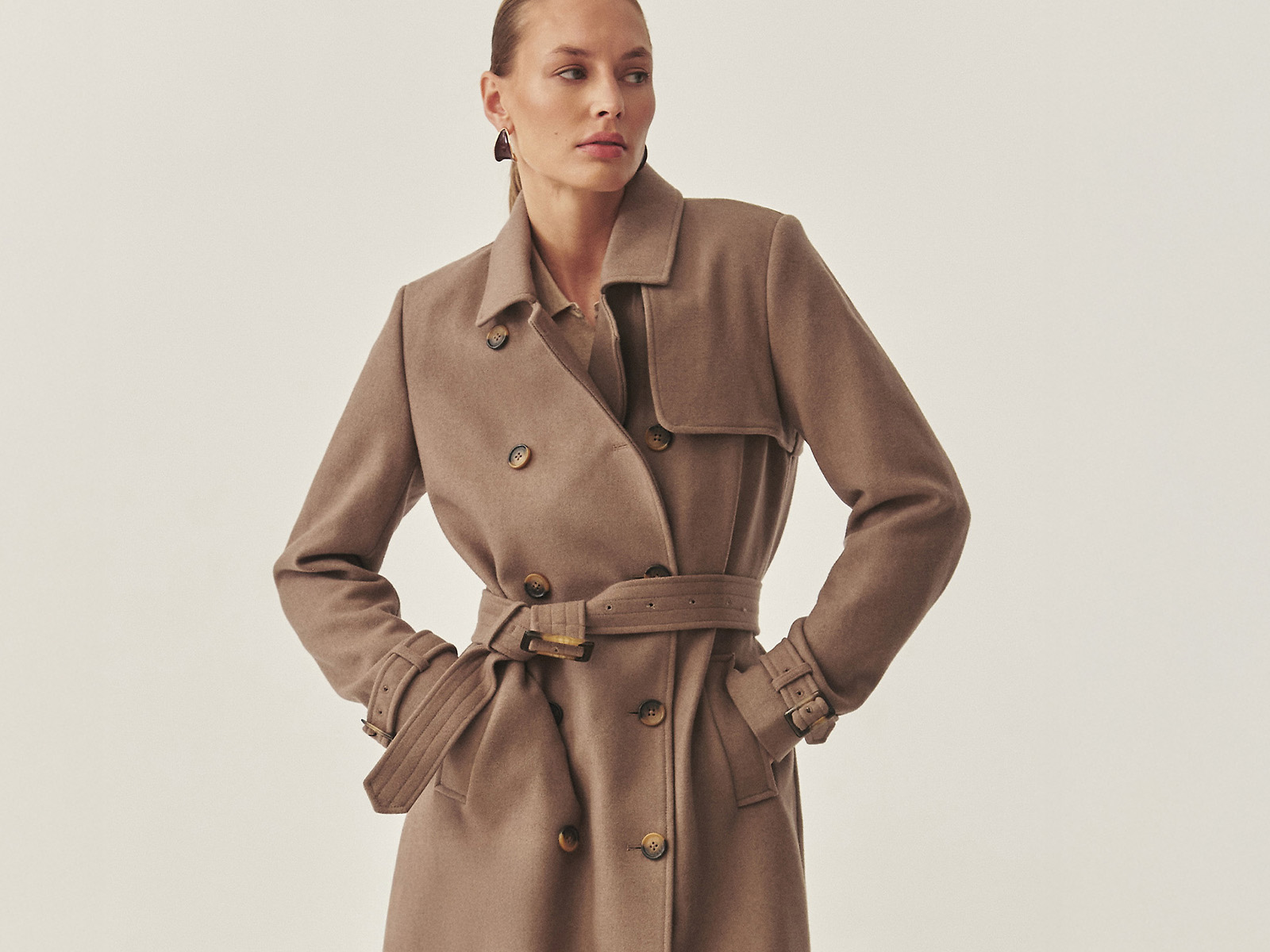 žena v béžovom vlnenom kabáte