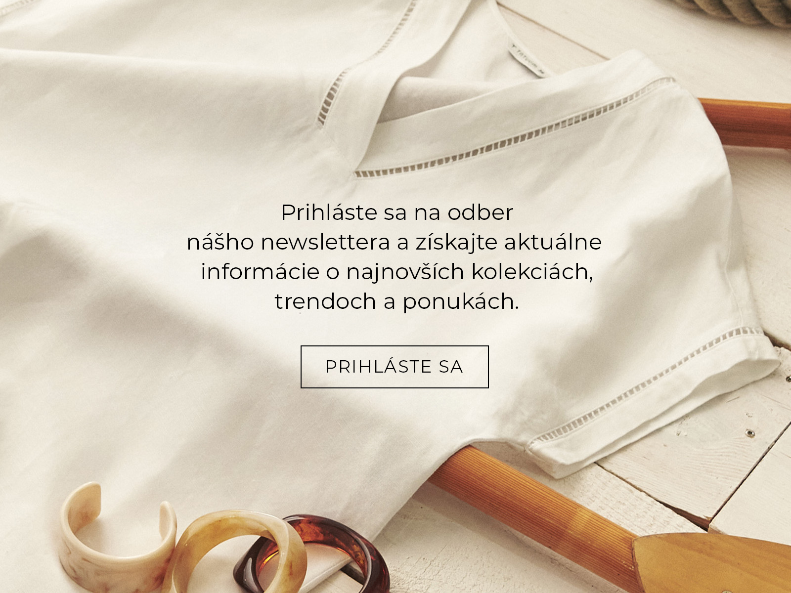 Pozvánka na odber newslettera TATUUM s bielym tričkom a bižutériou na drevenom pozadí.