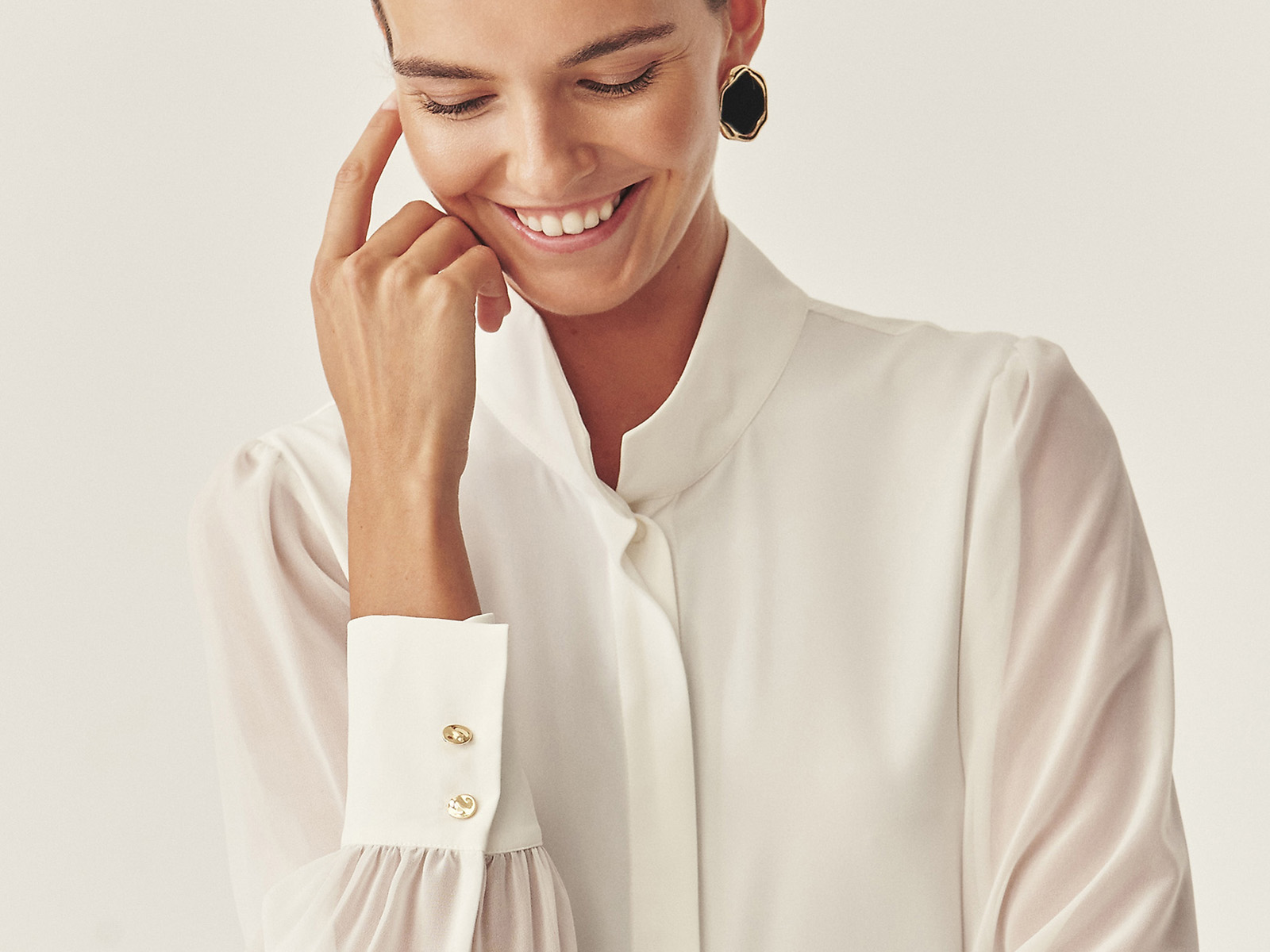 o femeie îmbrăcată într-o cămașă albă elegantă și pantaloni negri cu croi larg