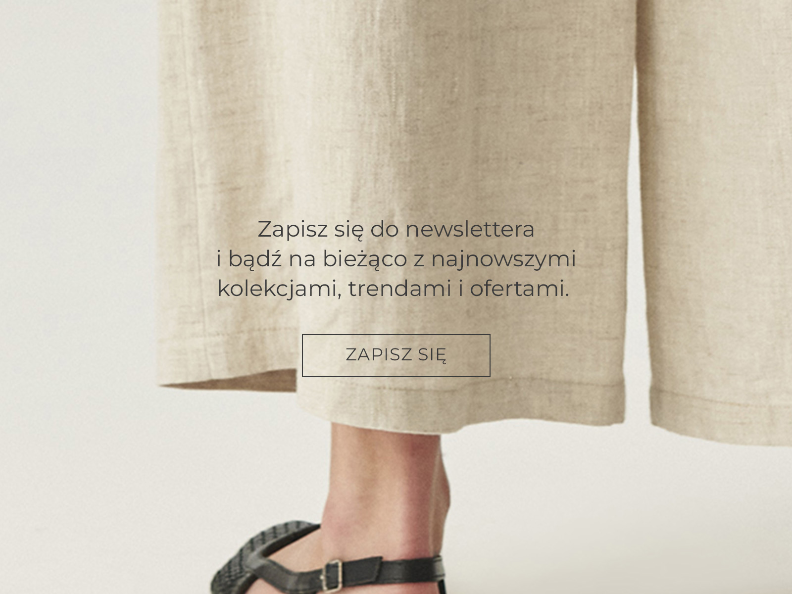 Napis z zachętą do zapisu na newsletter na tle zdjęcia ze zbliżeniem nogi w lnianych kulotach i czarnych sandałach.