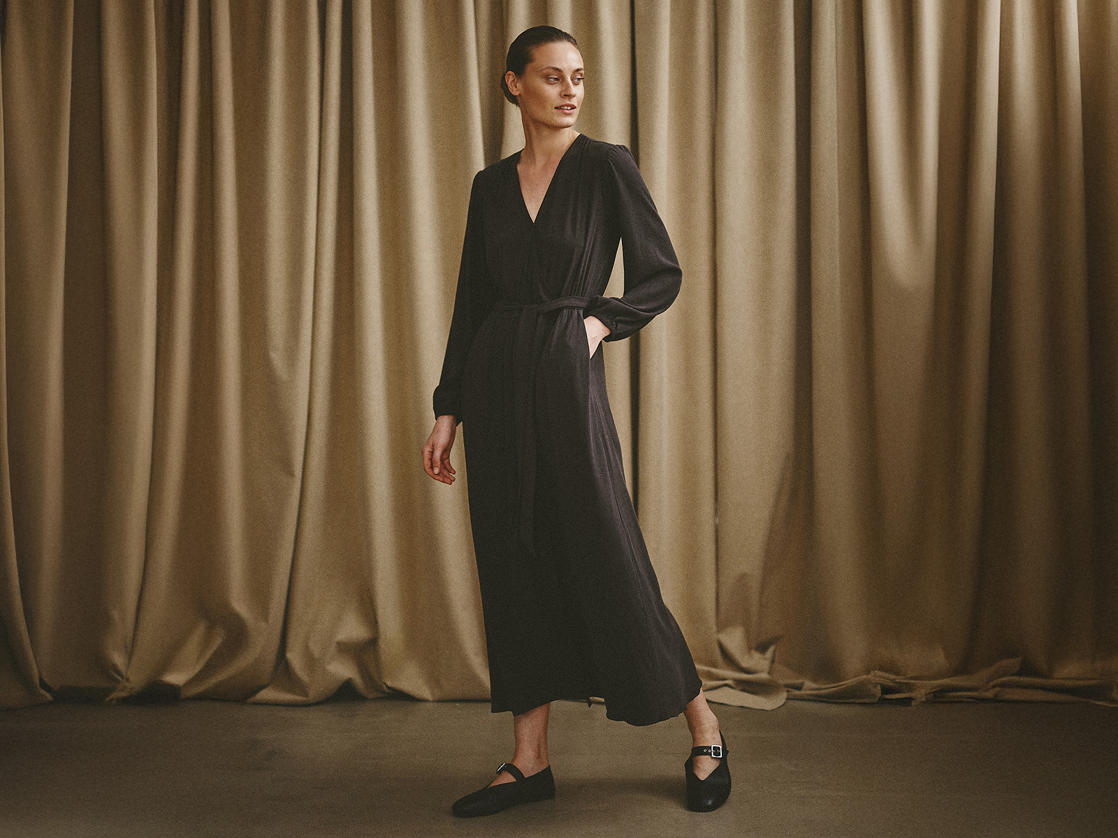 žena v elegantních hnědých midi šatech