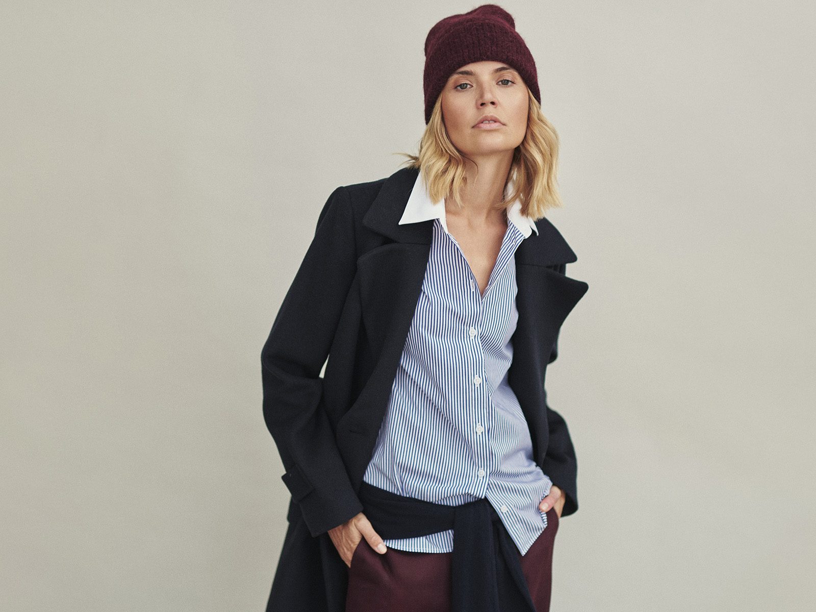 žena v elegantnom čiernom kabáte a klobúku