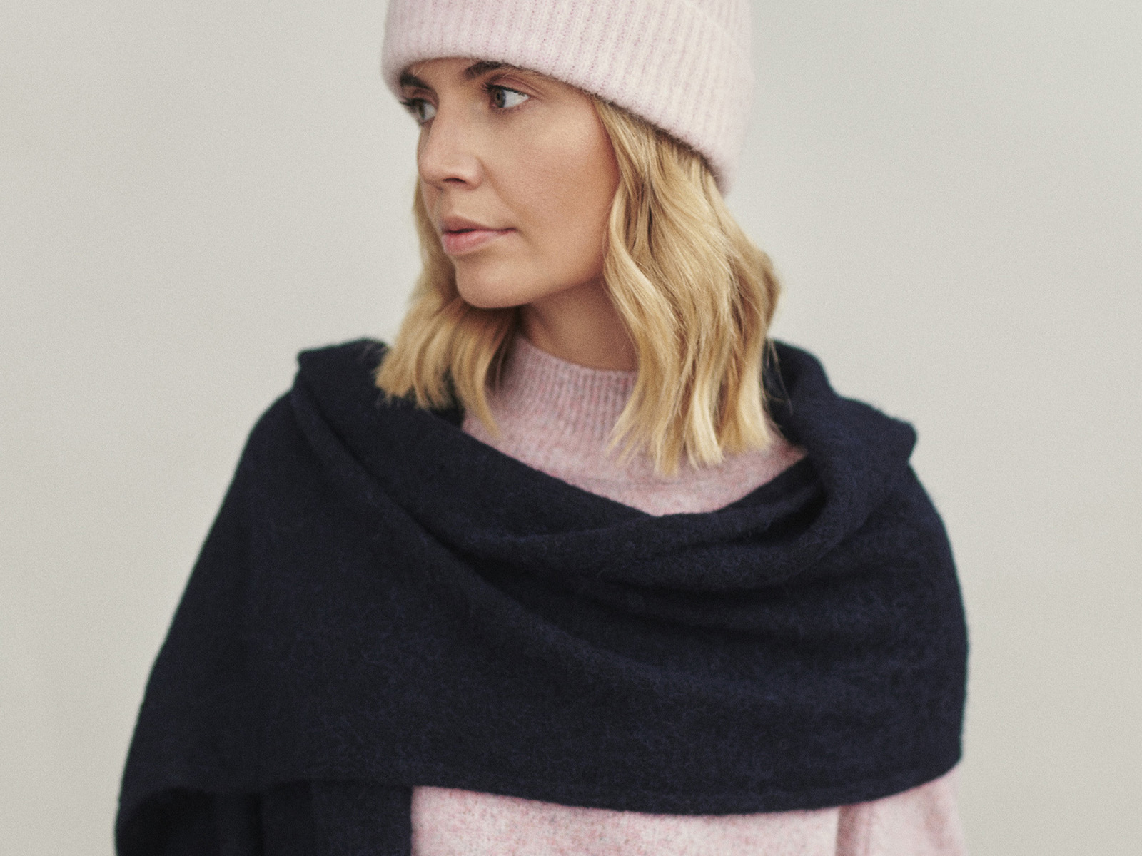 detailný záber na ženu s ružovým klobúkom a čiernym šálom