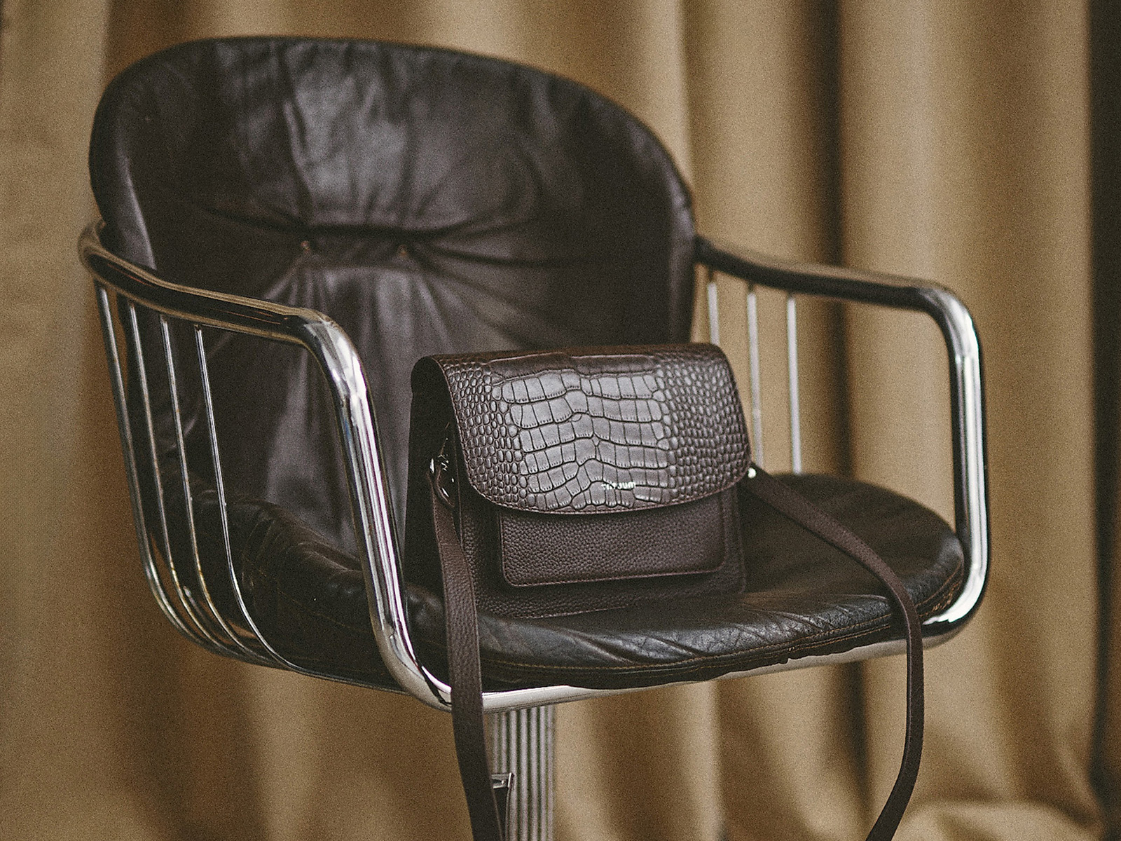 skórzana torba z wzorem na krześle