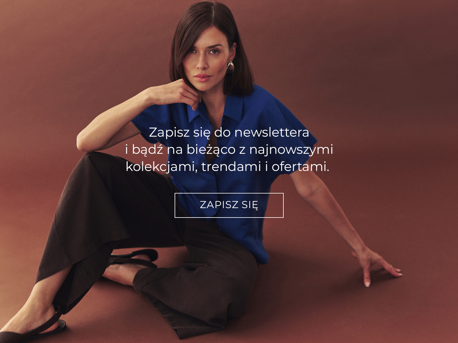 Kobieta w kobaltowej bluzce i brązowych spodniach i napis z zapisem do newslettera