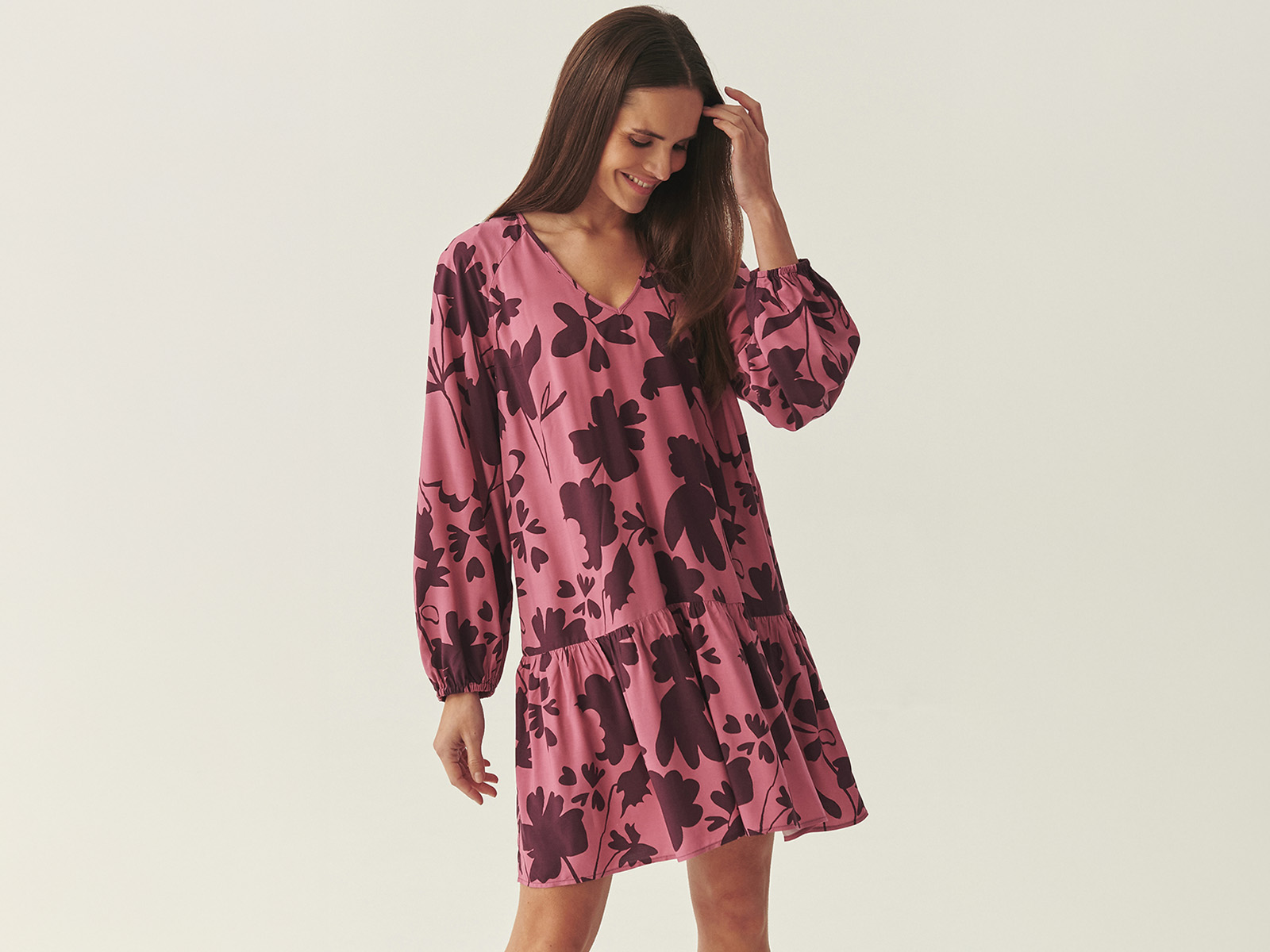 Kobieta w różowej sukience z nadrukiem w kwiaty